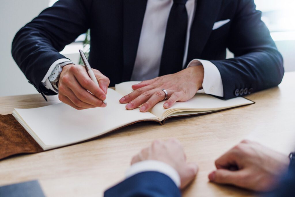 A real estate professional finalizing an investment deal for a client, symbolizing our company's commitment to providing expert guidance and seamless transactions in the real estate investment trust (REIT) sector.