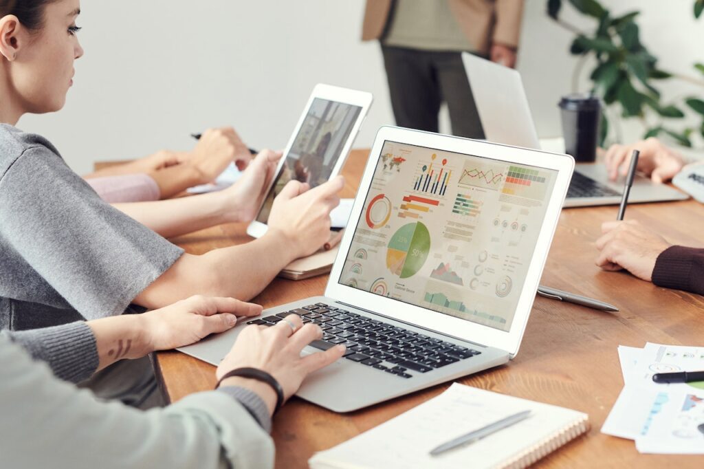 A team collaboratively analyzing data-driven marketing insights on a laptop, showcasing charts and graphs that reflect the Fortum Digital's expertise in leveraging advanced analytics to optimize real estate digital marketing strategies.